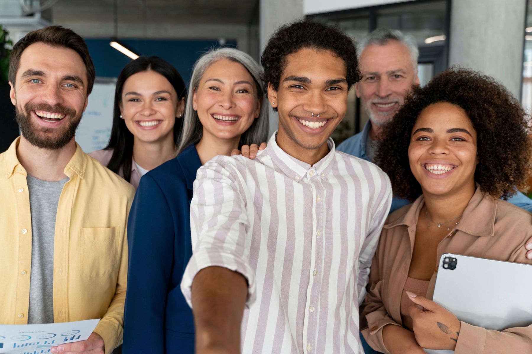 Servidores públicos de diferentes perfis sorrindo juntos no ambiente de trabalho